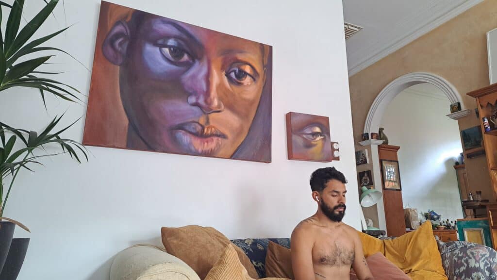 Hombre Meditando Sentado con Cuadro Arte de fondo