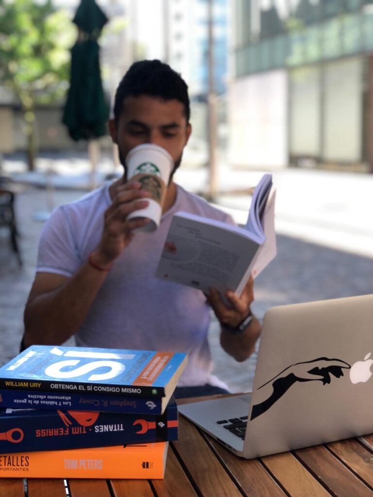 Hombre tomando Cafe de Starbucks Leyendo Libros